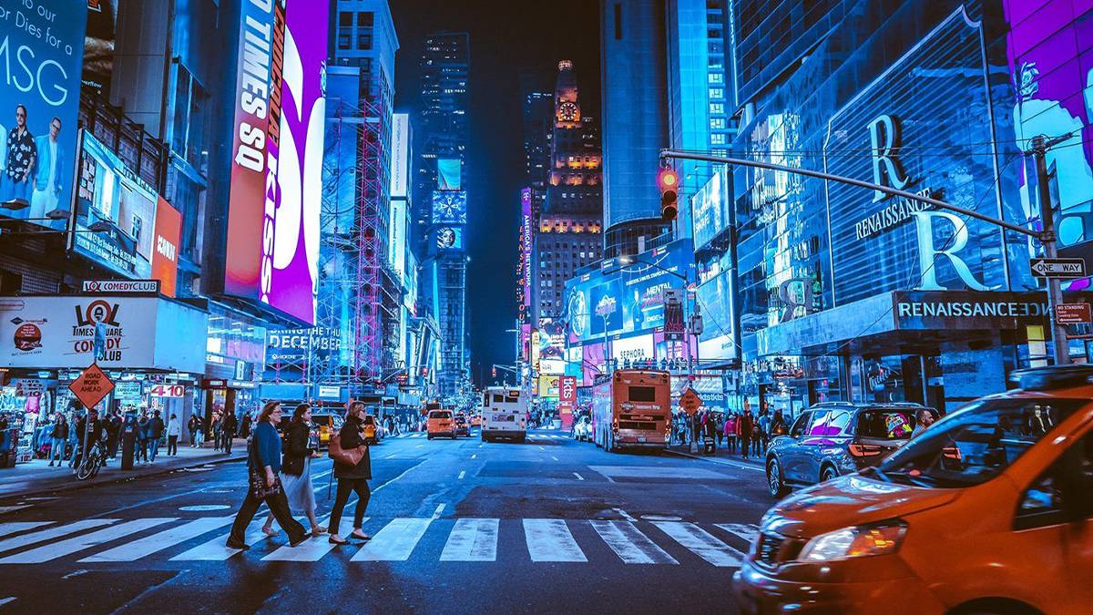 people crossing crosswalk at night in Times Square NYC, New York, USA